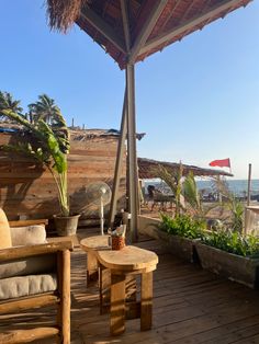 an outdoor area with wooden furniture and plants