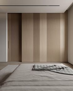 an empty bed in a room with wooden slats on the wall and carpeted floor