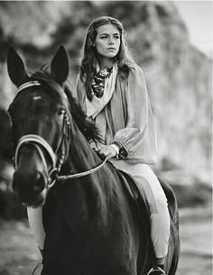 a woman riding on the back of a brown horse