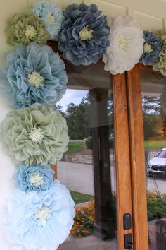 the front door is decorated with blue and white paper flowers, which are hanging on the wall