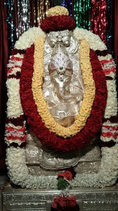 the statue is decorated with flowers and garlands