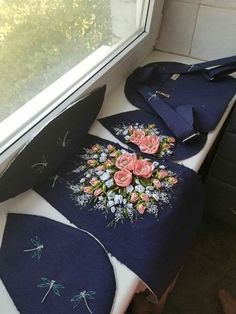 an umbrella with flowers and dragon embroidered on it sitting next to a window sill