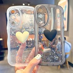 someone holding up two cases with hearts on them