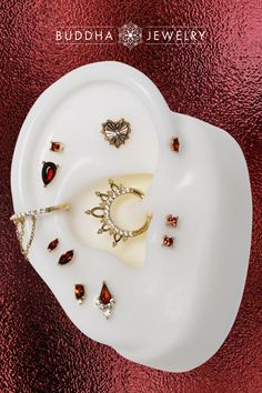 a white plate topped with jewelry on top of a red table