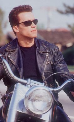 a man in black jacket and sunglasses on motorcycle