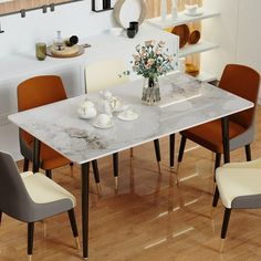 a dining room table with chairs and a vase filled with flowers on top of it