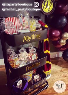 a harry potter themed birthday party with balloons and candy on the shelf for guests to enjoy