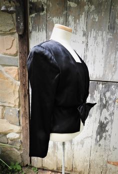 "GREAT New Old Stock Vtg 1980's Prophecy Black Sateen Dress Blouse Shoulder Pads sz S/6 This is a lovely vintage black sateen blouse from the 1980's. It is new old stock and does appear unworn or washed to me. It's in great condition. The collar is squared off like a sailor shirt. It is secured at the front with a snap and hook just under the large bow which sits at the waistline. The front has a rushed collar line and there are large shoulder pads here. This blouse is lined and marked a vintage Retro Long Sleeve Blouse For Evening, Retro Long Sleeve Evening Blouse, Vintage Silk Blouse For Evening, Fitted Vintage Blouse With Square Neck, Vintage Black Blouse For Formal Occasions, Vintage Silk Tops For Evening, Retro Fitted Evening Tops, Vintage V-neck Blouse For Formal Occasions, Retro Fitted Silk Top