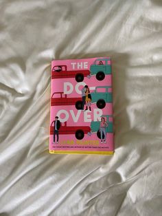 a pink book sitting on top of a bed covered in white sheets and pillows with the title, the art of pot over