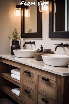 two sinks in a bathroom with mirrors and lights on the wall above them, along with towels