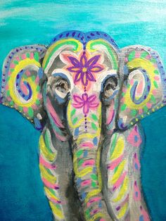 an elephant painted in bright colors with flowers on it's face and trunk, standing against a blue background