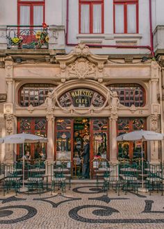 an old building with tables and umbrellas outside