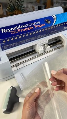 a person is using a machine to cut paper