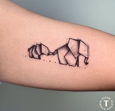 an elephant tattoo on the arm with two elephants touching each other's trunks,