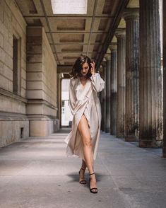 a woman is walking down the street in a long dress