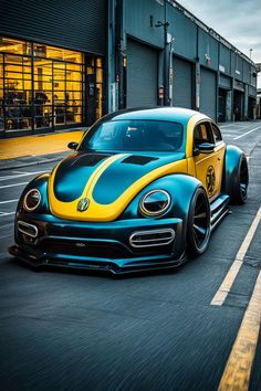 a blue and yellow bug is driving down the street