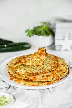 a white plate topped with food next to cucumbers