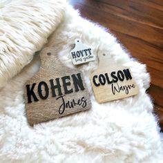 two wooden tags that say kohen, colson and james hang on a white rug