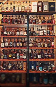 the shelves are filled with various types of liquor