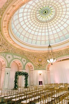 the inside of a building with rows of chairs in front of a domed glass ceiling