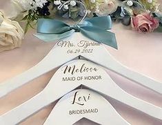 wedding hangers with personalized names on them and flowers in front of the bride's bouquet