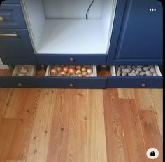 an open refrigerator sitting on top of a hard wood floor next to a wooden floor