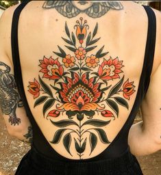 the back of a woman's body with tattoos on it