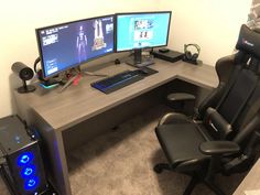 an office desk with two computer monitors and a gaming chair in front of the monitor