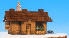 a small house made out of wood and bricks on top of a snow covered hill