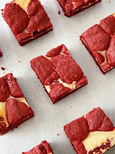 red velvet dessert squares with white icing on a baking sheet, ready to be eaten