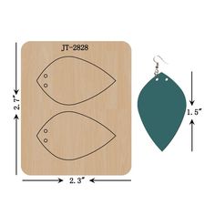 a pair of fish shaped wooden earrings next to a wood board with measurements for each earring