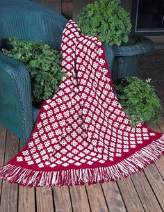 a red and white blanket sitting on top of a wooden floor