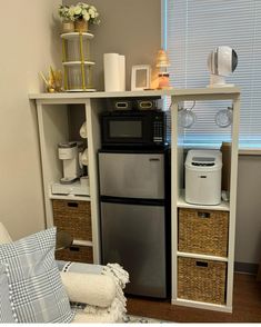 a kitchen with a microwave, refrigerator and other items on the shelves in front of it