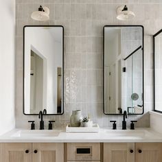 a bathroom with two sinks and mirrors on the wall