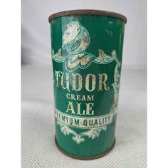 an old tin cup with the words tudor cream ale written in gold and green on it