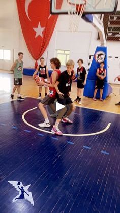 a group of young men standing on top of a basketball court