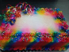 a rainbow cake decorated with ribbons and bows