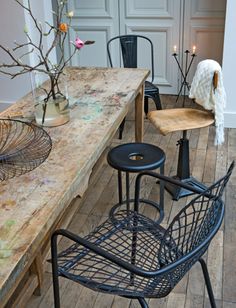 two chairs and a table with flowers in vases on it are sitting next to each other