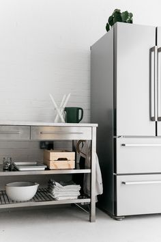 a white refrigerator freezer sitting next to a metal shelf