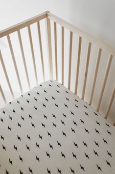 a crib with a white sheet and black stars on it