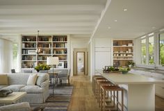 a living room filled with furniture next to a kitchen