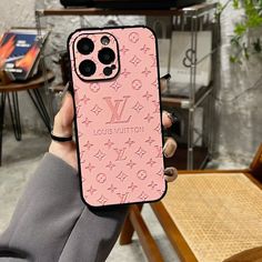 a person holding up a pink louis vuitton phone case