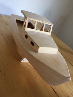 a small wooden boat sitting on top of a wooden floor