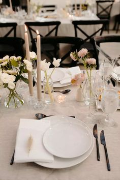 the table is set with white plates and silverware