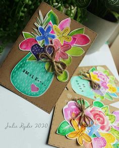 two cards with flowers on them sitting next to each other, one has a tag that says smile