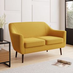 a yellow couch sitting on top of a hard wood floor