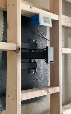 an electrical device mounted to the side of a wooden ladder in a room that is being remodeled