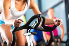 a woman on a stationary bike with the words stop spinning your wheels