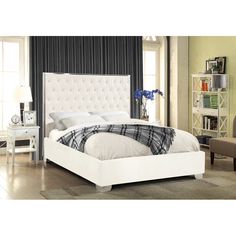 a white bed sitting in a bedroom on top of a hard wood floor