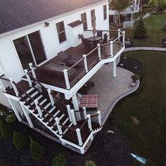 an aerial view of a white house with deck and railings in the front yard